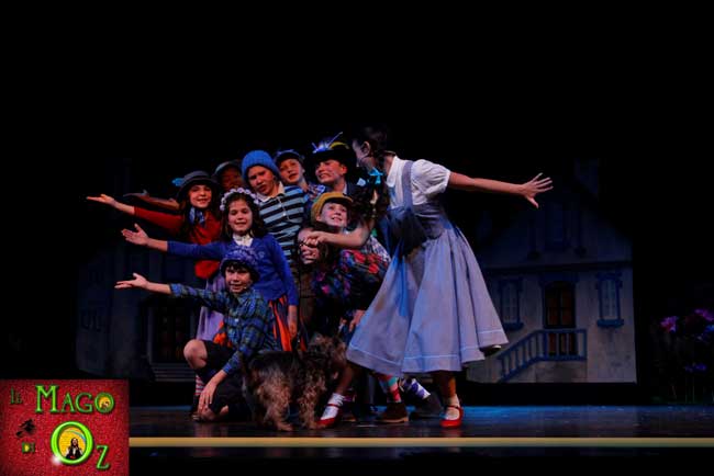 Una scena del musical Il Mago di Oz: i Mastichini indicano a Dorothy il Dorato Sentier che la condurrà ad Oz, dal celebre Mago Una scena del musical Il Mago di Oz: i Mastichini indicano a Dorothy il Dorato Sentier che la condurrà ad Oz, dal celebre Mago